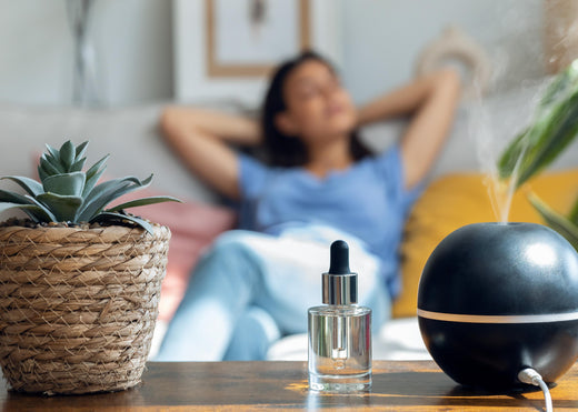a girl laying on a sofa after putting essential oil on the table