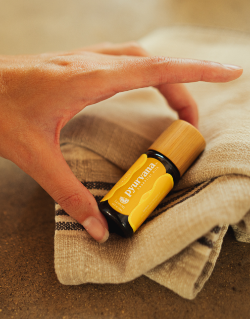 pyurvana lemon essential oil kept on a towel by a girl hand