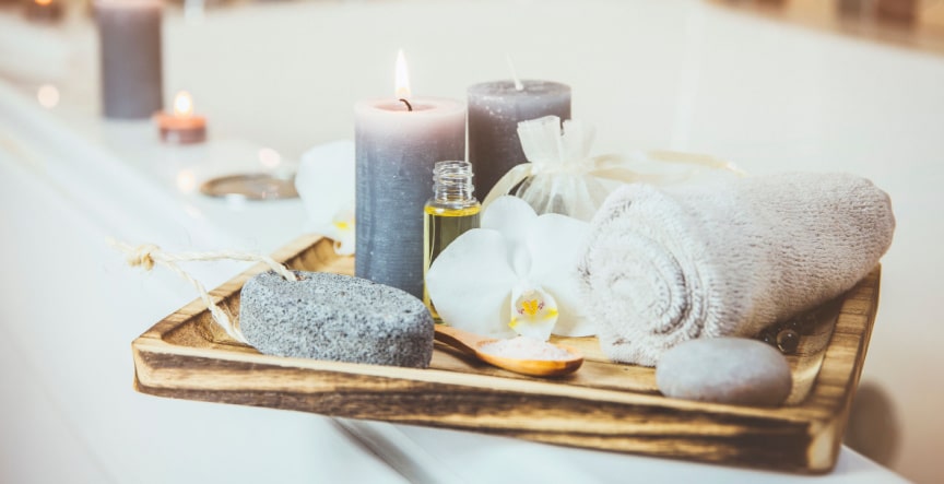 spa tray with pyurvana essential oil along with towel and candles