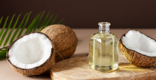 essential oil in a small glass bottle on the wooden deck along with coconut