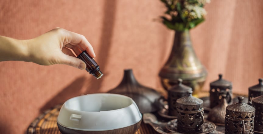 pyurvana essential oil being poured in a oil diffuser