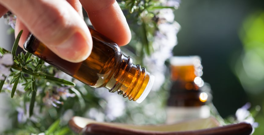 rosemary pyurvana essential oil being poured on a bowl
