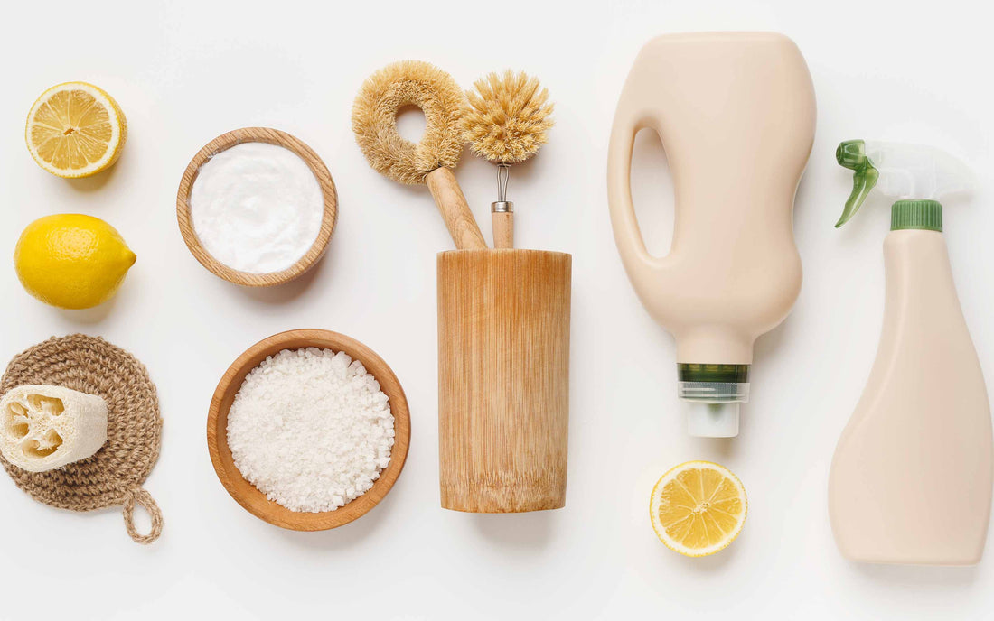 Natural cleaning supplies with lemons, baking soda, sea salt, and eco-friendly brushes