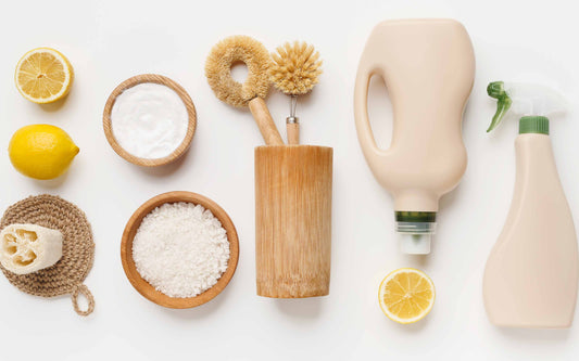 Natural cleaning supplies with lemons, baking soda, sea salt, and eco-friendly brushes